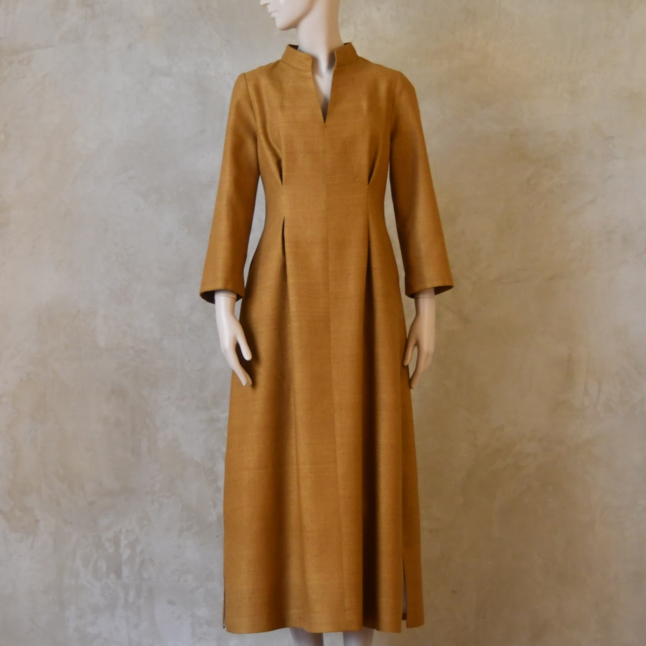 Full length shot of Tan coloured tailored formal wear silk dress. Three quarter length sleeves, fully lined in silk with gathering darts at front and rear creating flattering hourglass shape. Handmade in London.