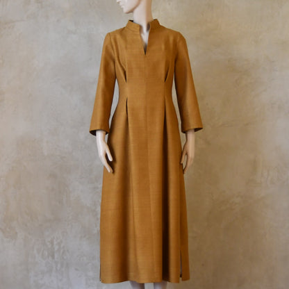 Full length shot of Tan coloured tailored formal wear silk dress. Three quarter length sleeves, fully lined in silk with gathering darts at front and rear creating flattering hourglass shape. Handmade in London.