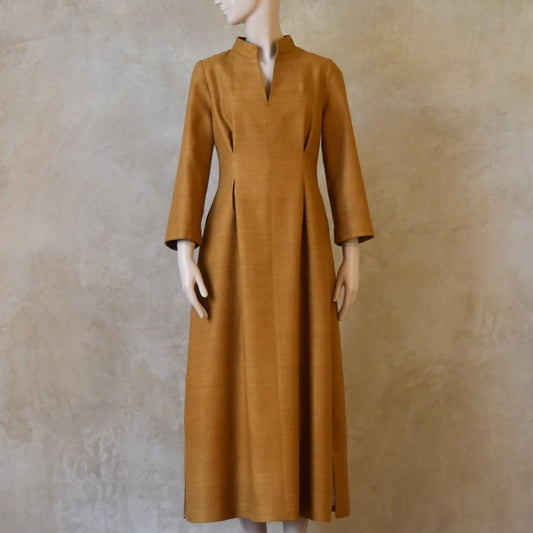Full length shot of Tan coloured tailored formal wear silk dress. Three quarter length sleeves, fully lined in silk with gathering darts at front and rear creating flattering hourglass shape. Handmade in London.