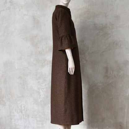 Side view of Bespoke Houndstooth patterned Merino Flannel Coat by EdNerat. Handmade in London, this A-Line longer length coat has gathered details at the shoulders, bell sleeves and is lined in pure silk. Woven in Somerset  by Fox Brothers and Handmade in London. 