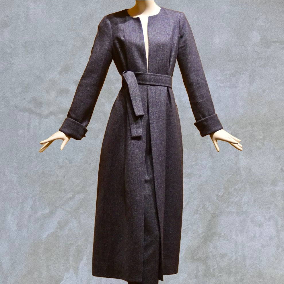 Fitted and tailored hourglass coat in Denim Blue Herringbone Lambswool Tweed over a matching long skirt. Handmade in Britain. Shown Belted.