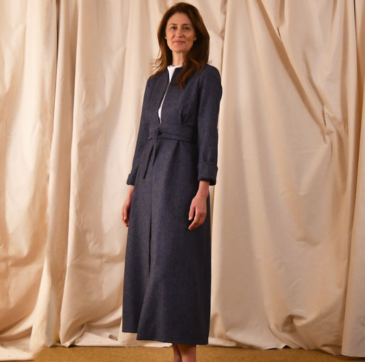 Fitted and tailored hourglass coat in Denim Blue Herringbone Lambswool Tweed over a matching long skirt. Handmade in Britain. Closed View.