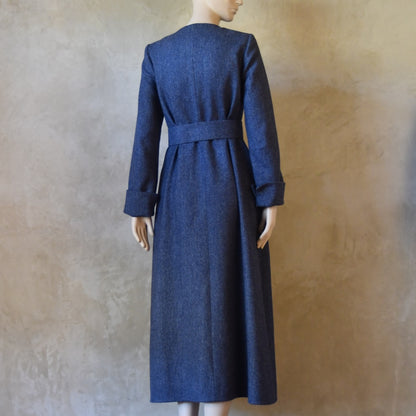 Rear belted view of Bespoke Hourglass Tweed Coat, Handmade in London. Denim Blue herringbone tweed dress coat, ideal for winter weddings, race fixtures and other formalwear occasions. Fully lined in pure silk, with optional Nehru collar, fold back cuffs and self-fabric wrap around belt.
Longer or calf length coat.