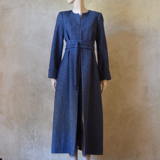 Bespoke Belted Blue Tweed Coat, Handmade in London. Denim Blue herringbone tweed dress coat, ideal for winter weddings, race fixtures and other formalwear occasions. Fully lined in pure silk, with optional Nehru collar, fold back cuffs and self-fabric wrap around belt.
Longer or calf length coat.