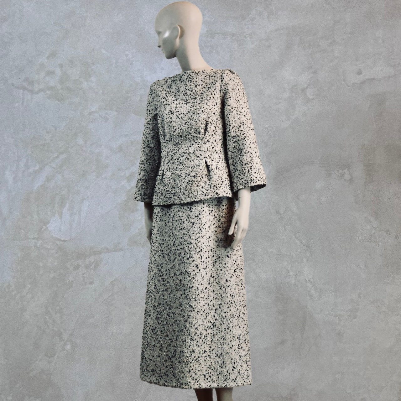 A Tailored Boat Neck Blouse in Linton Tweeds Boucle and a matching calf-length skirt. A chic, light-hued two-piece with long sleeves. Handmade in Britain.