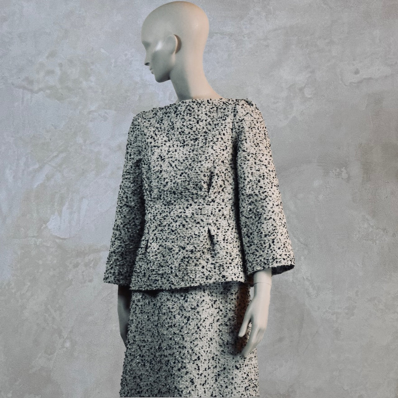 A Tailored Boat Neck Blouse in Linton Tweeds Boucle and a matching calf-length skirt. A chic, light-hued two-piece with long sleeves. Handmade in Britain.