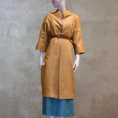 Summer silk cocoon coat in tan silk makta. Fully lined in silk and handmade in London, this coat is a perfect summer weight and can be worn open or belted as shown in the photograph.