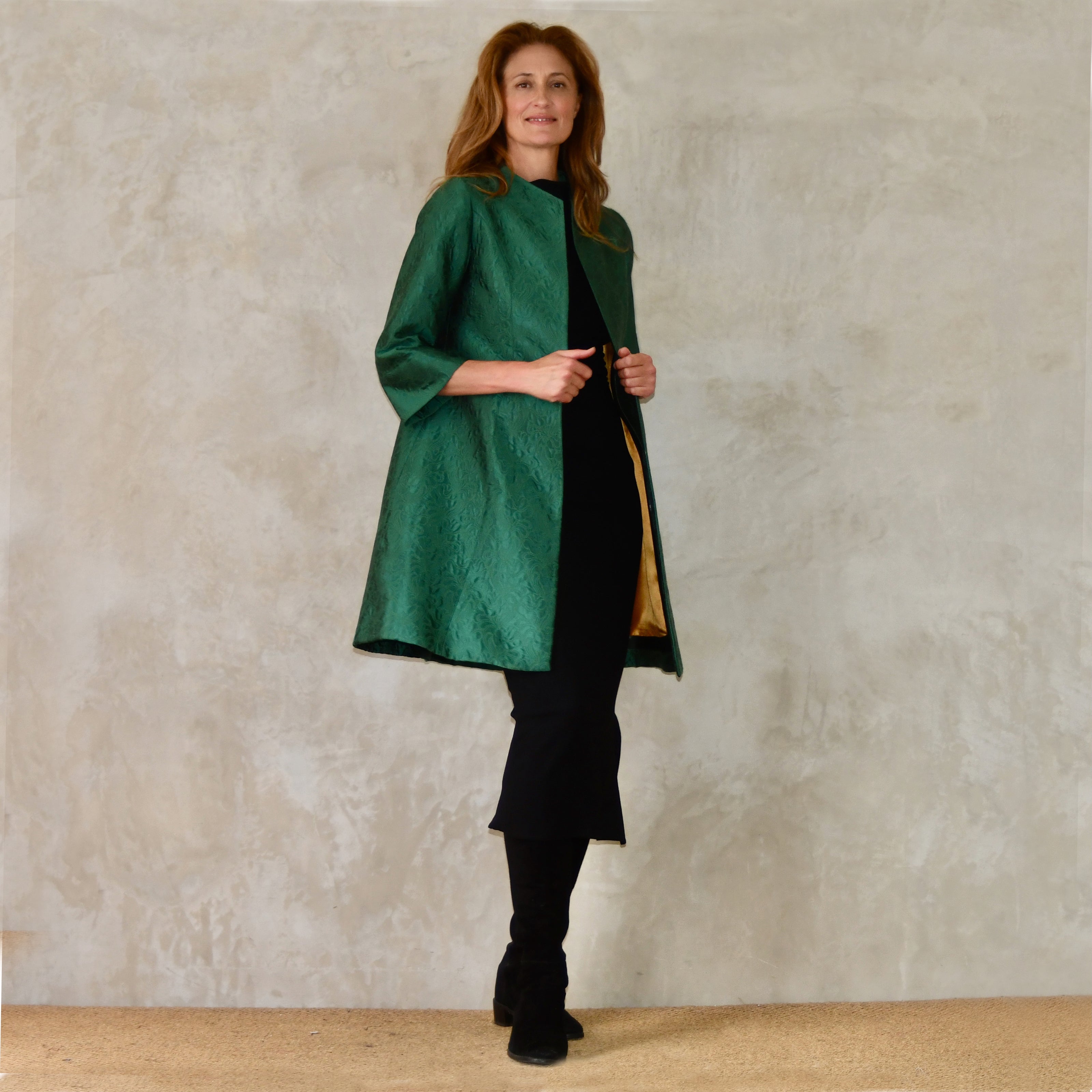 Bespoke Trapeze coat in Emerald Brocade. A Mid-Length swing coat in a luxurious silky green self-patterned fabric. 
Handmade in Britain. Side View.