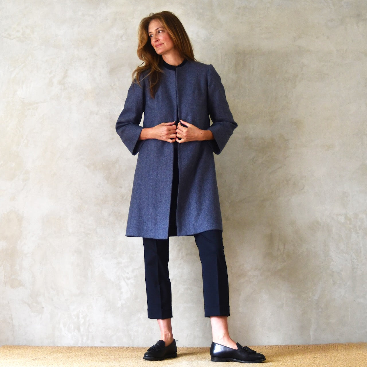 Trapeze coat in Blue Yorkshire Tweed. With a denim blue herringbone patterning, the supple tweed falls gracefully on this Bespoke Coat which is Handmade in Britain. Front View.