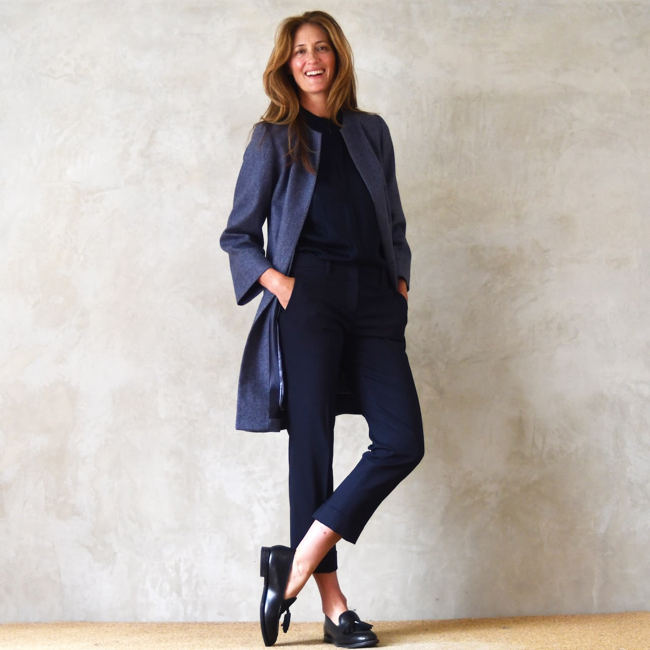 Trapeze coat in Blue Yorkshire Tweed. With a denim blue herringbone patterning, the supple tweed falls gracefully on this Bespoke Coat which is Handmade in Britain. Side View.