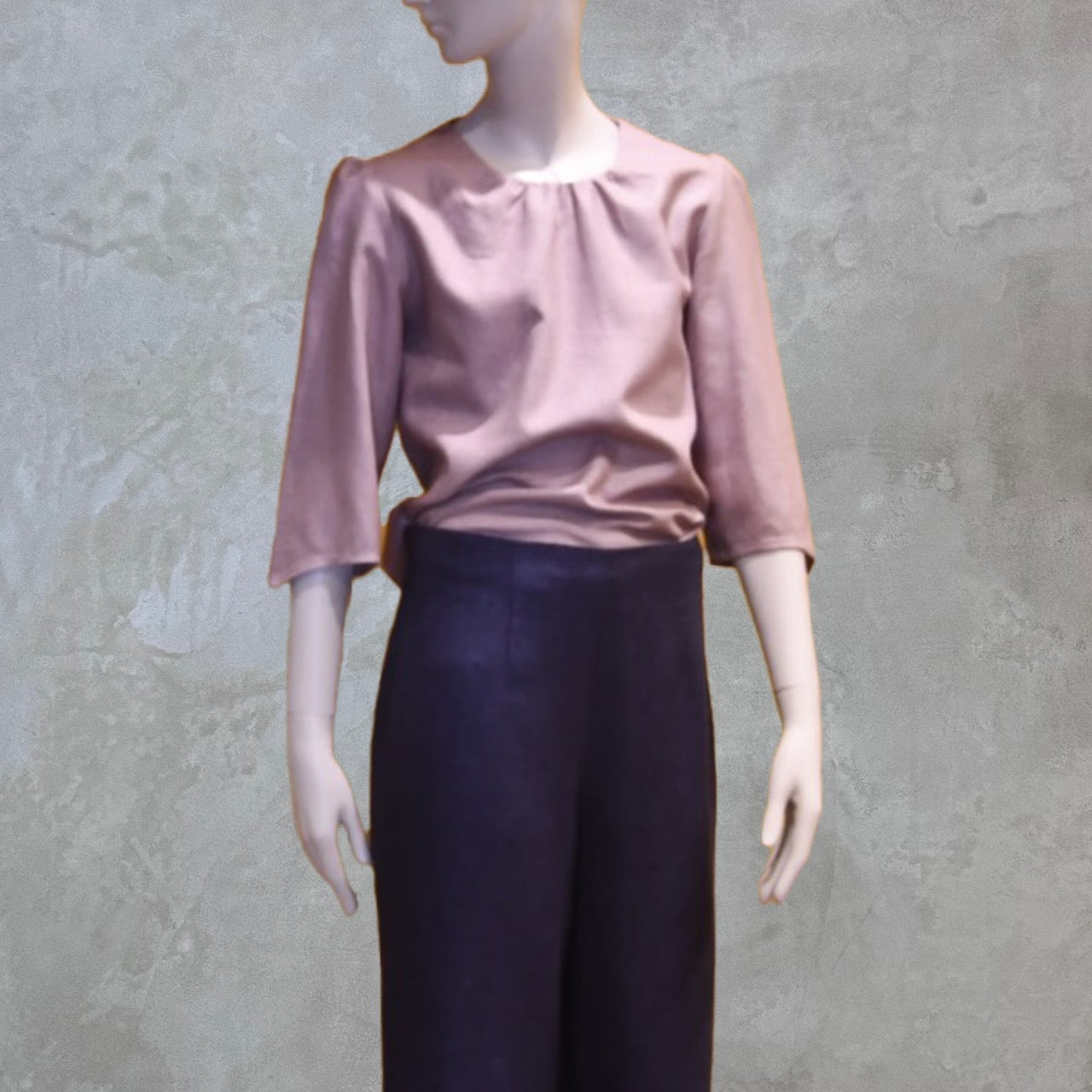 A Gathered Neck Puff Sleeve Blouse in Antique Rose Silk Matka. Shown with high-waisted inky-blue silk trousers. A refined ensemble defined by elegant lines.  Handmade in Britain. 