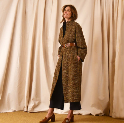 Long cocoon coat in Linton Tweeds Golden Brown, Black and Camel Boucle. Shown belted at the waist, this elegant coat falls tot he mid calf. Handmade in Britain.