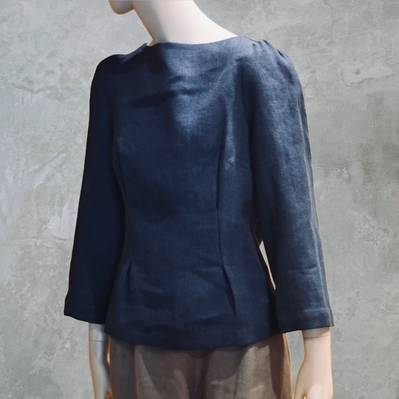 Close up showing Navy Linen Boat Neck Top. Handmade in London, this top has a boat neck, rear zip and tailoreddarts to front and rear creating a simple elegant peplum shape that is hugely flattering on shapes and sizes.