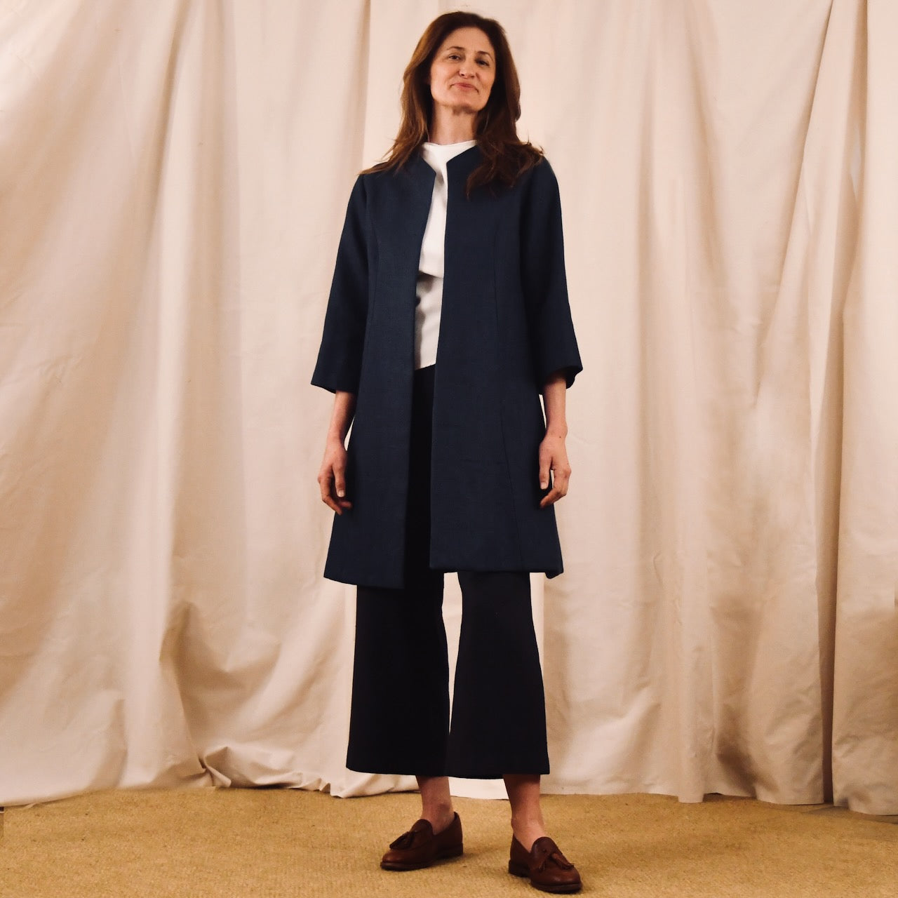 Trapeze Swing Coat in Navy Heavier Weight Irish Linen. Navy Linen MidLength Swing Coat with slight vintage feel and flattering seaming details to front and rear. Entirely made in Great Britain. Front open view. Full View