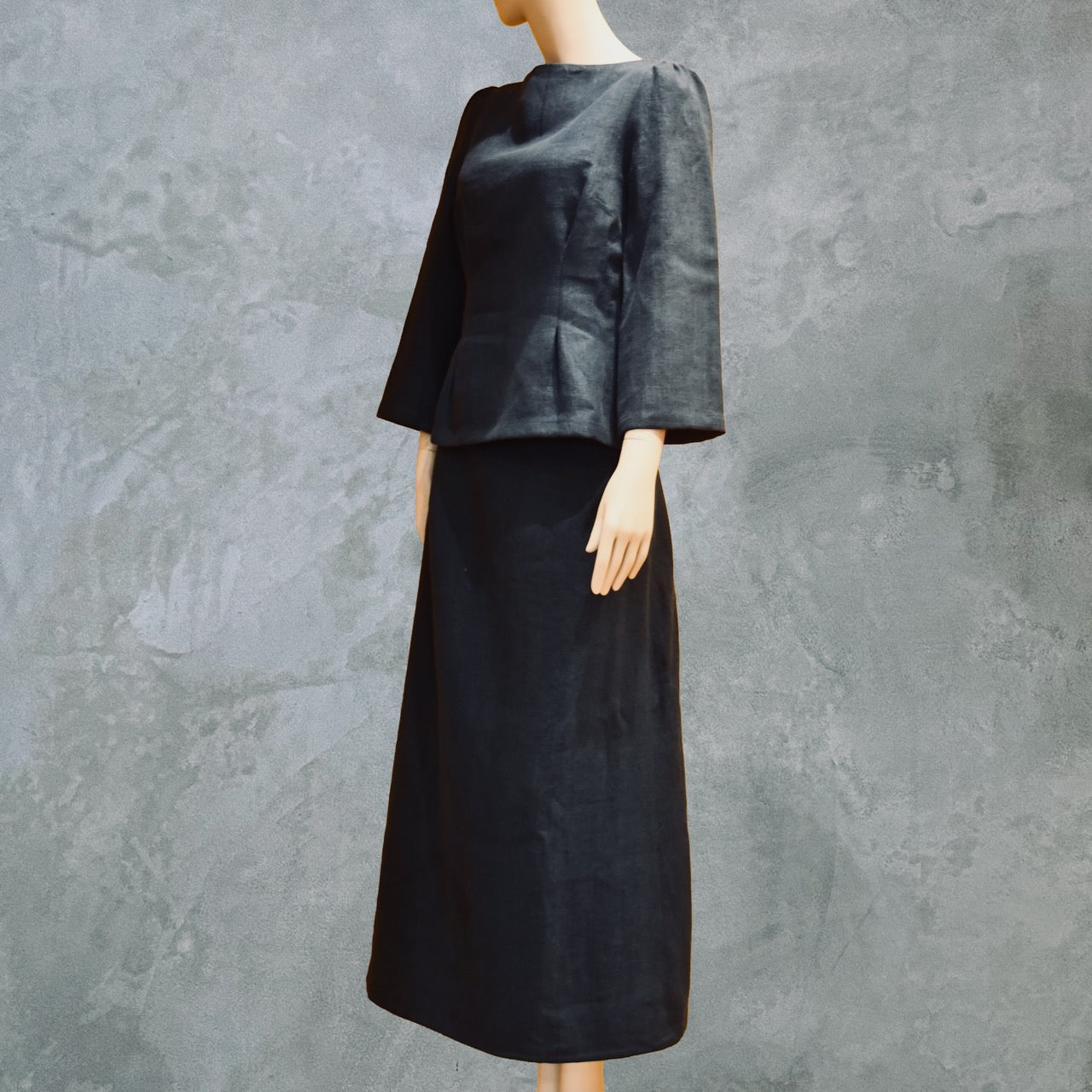 Side Front View of bespoke Navy Tailored Linen Skirt Suit showing boatneck peplum shaped cop over longer length A-Line Skirt. Cut, Made and Finished by Hand n London, bespoke lengths and sizes are also available.
