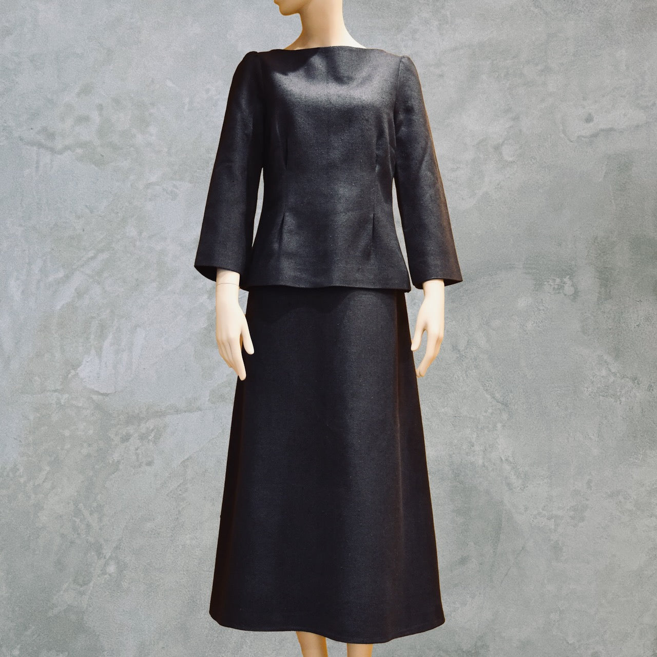 Tailored Summer Skirt Suit in dark navy blue. A boatneck top with a gentle peplum shape sits atop a longer length A-Line skirt. Both fully lined in Silk  and handmade in London. Bespoke skirt suits are also available.