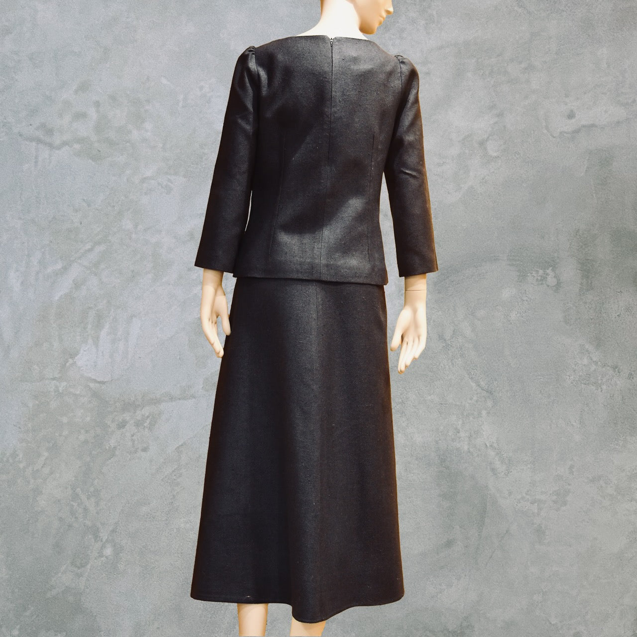 Back view of Tailored Summer Skirt Suit in dark navy blue. A boatneck top with a gentle peplum shape sits atop a longer length A-Line skirt. Both fully lined in Silk  and handmade in London. Bespoke skirt suits are also available.