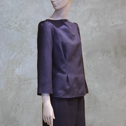 A Tailored Boat Neck Blouse in DarkBlue-Black Silk Matka with a matching skirt, posed sideways. A refined ensemble defined by elegant lines. Handmade in Britain. 