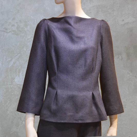 A Tailored Boat Neck Blouse in DarkBlue-Black Silk Matka with a matching skirt, posed sideways. Handmade in Britain. A refined ensemble defined by elegant lines.