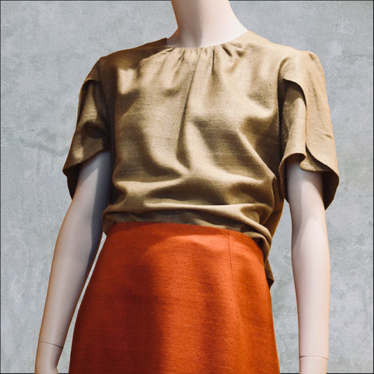 A Tulip Sleeve Blouse in Khaki Silk Matka. Handmade in Britain. Shown paired with a rust-orange silk skirt.