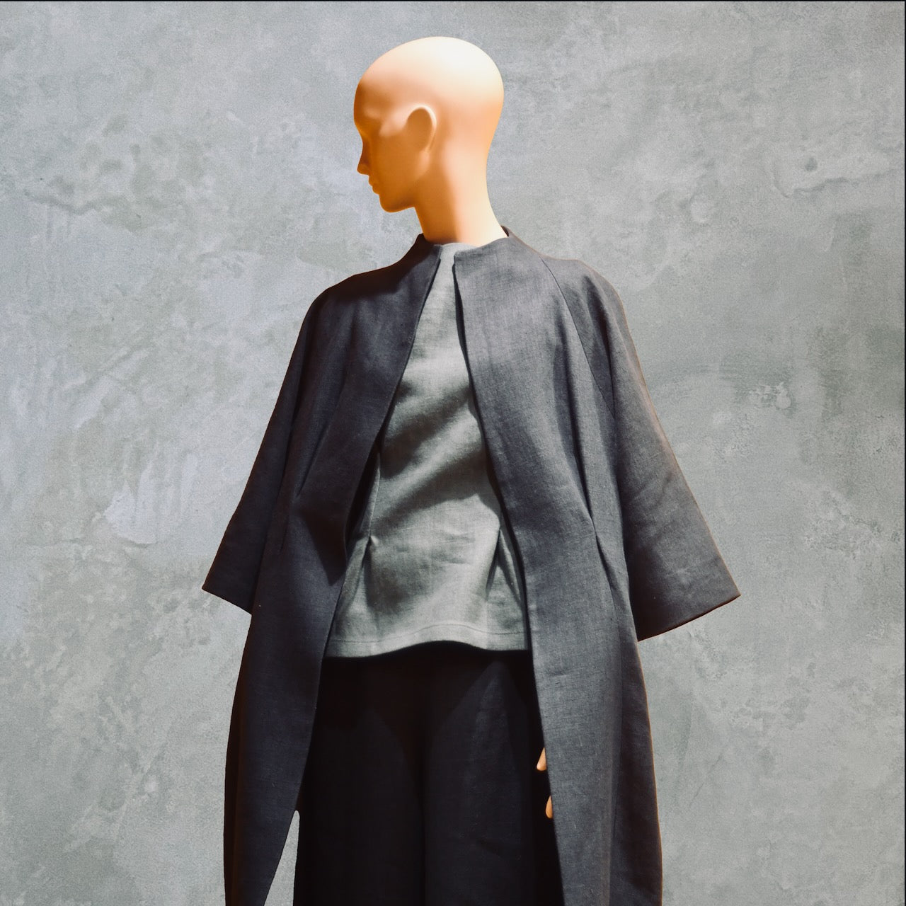 Tailored Boat Neck Blouse in Seafoam Blue Linen, paired with a navy linen cocoon coat and navy linen pants. All made by EdNerat. All made by Hand in Great Britain.