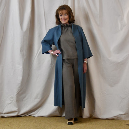Irish Linen Cocoon Coat in mid blue. This longer length cocoon coat has tucks to front and rear, side pockets and bracelet length sleeves . Handmade in Britain.