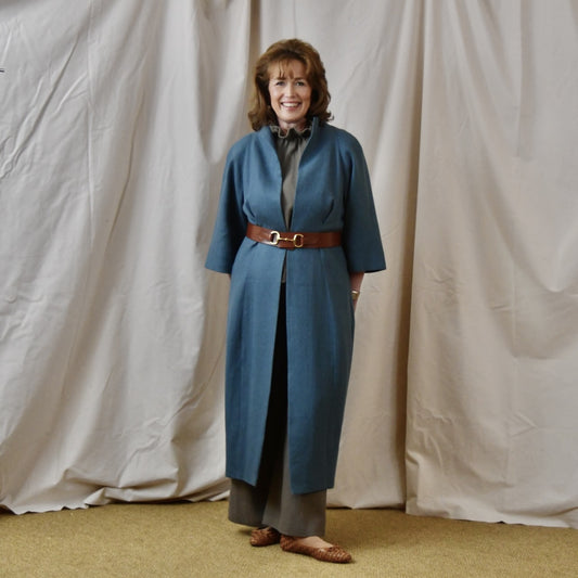 Irish Linen Cocoon Coat in mid blue. This longer length cocoon coat has tucks to front and rear, side pockets and bracelet length sleeves . Handmade in Britain.
