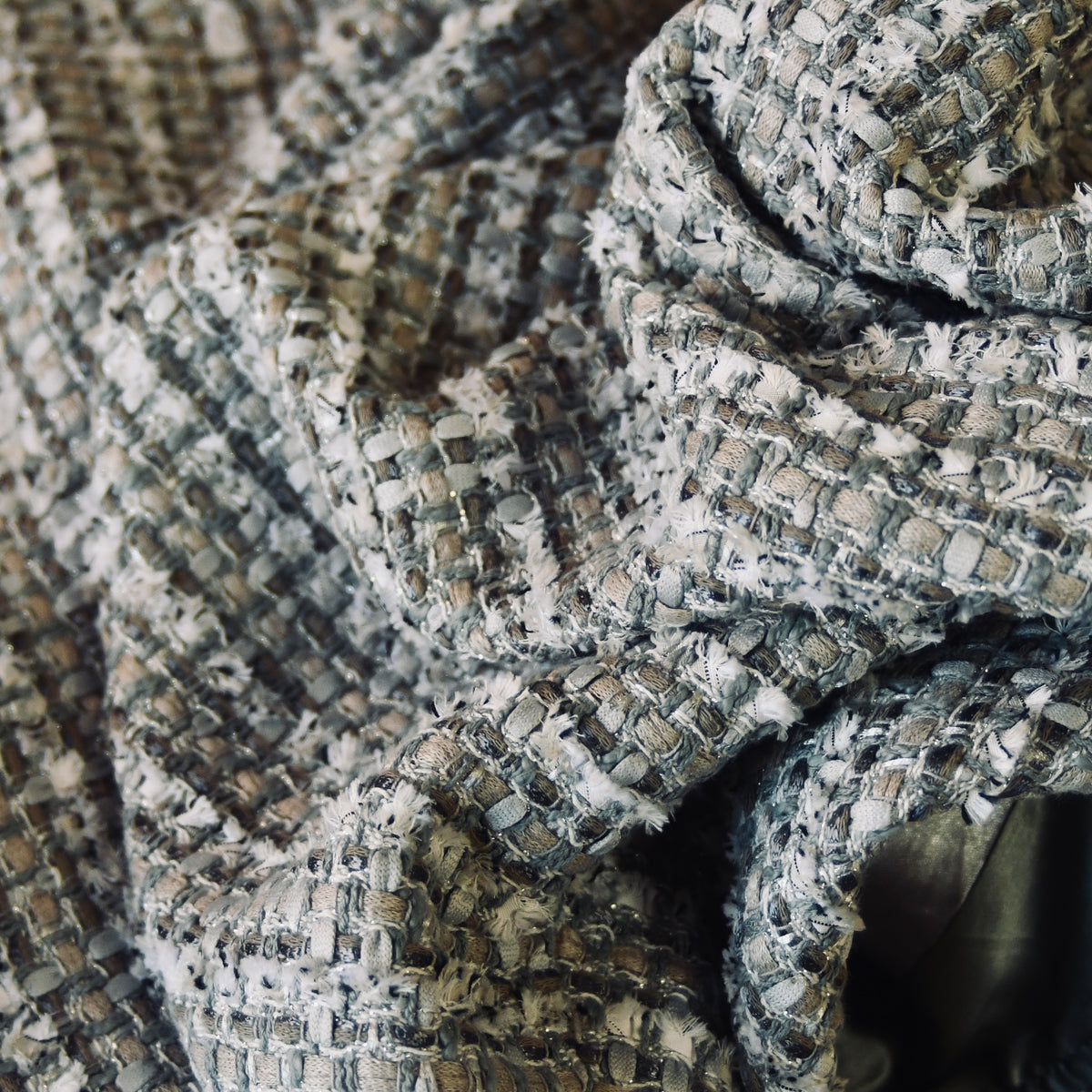 Close-up of Cape in Silver Mix Boucle by Linton Tweeds. The Silver Mix Boucle, featuries gray, silver and white tones with a loose, textured weave. Made by Hand in Great Britain..