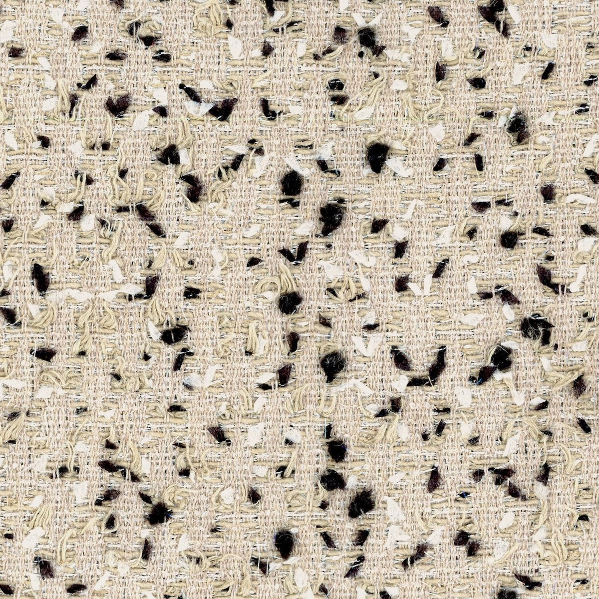 Close-up of a hand-made beige woven fabric with black and white irregular flecks and threads, creating a textured, bespoke surface.