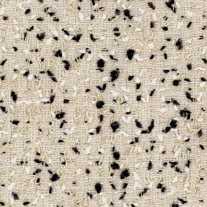 Close-up of a hand-made beige woven fabric with black and white irregular flecks and threads, creating a textured, bespoke surface.