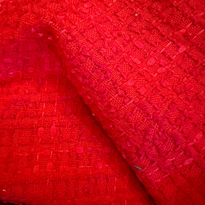 Close-up of textured red fabric on EdNerat’s Tailored Boat Neck Blouse in Linton TWeeds Boucle, highlighting a raised geometric pattern, soft material, and visible woven details with subtle color and weave variations.