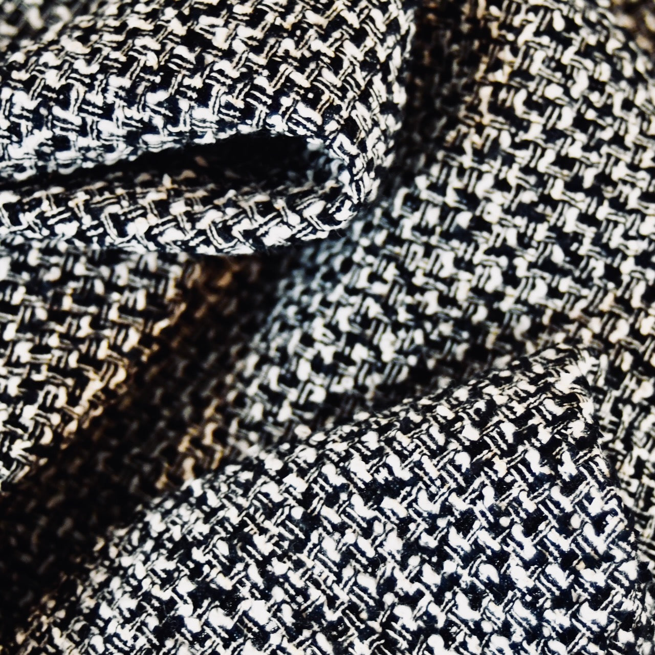 Close-up of EdNerats a Waisted A-Line Skirt in Boucle, featuring black and white textured checkered Linton Tweeds fabric with soft folds—ideal for styling an elegant A-line look.