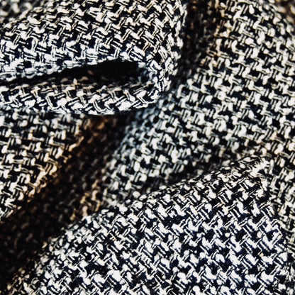 Close-up of EdNerats a Waisted A-Line Skirt in Boucle, featuring black and white textured checkered Linton Tweeds fabric with soft folds—ideal for styling an elegant A-line look.