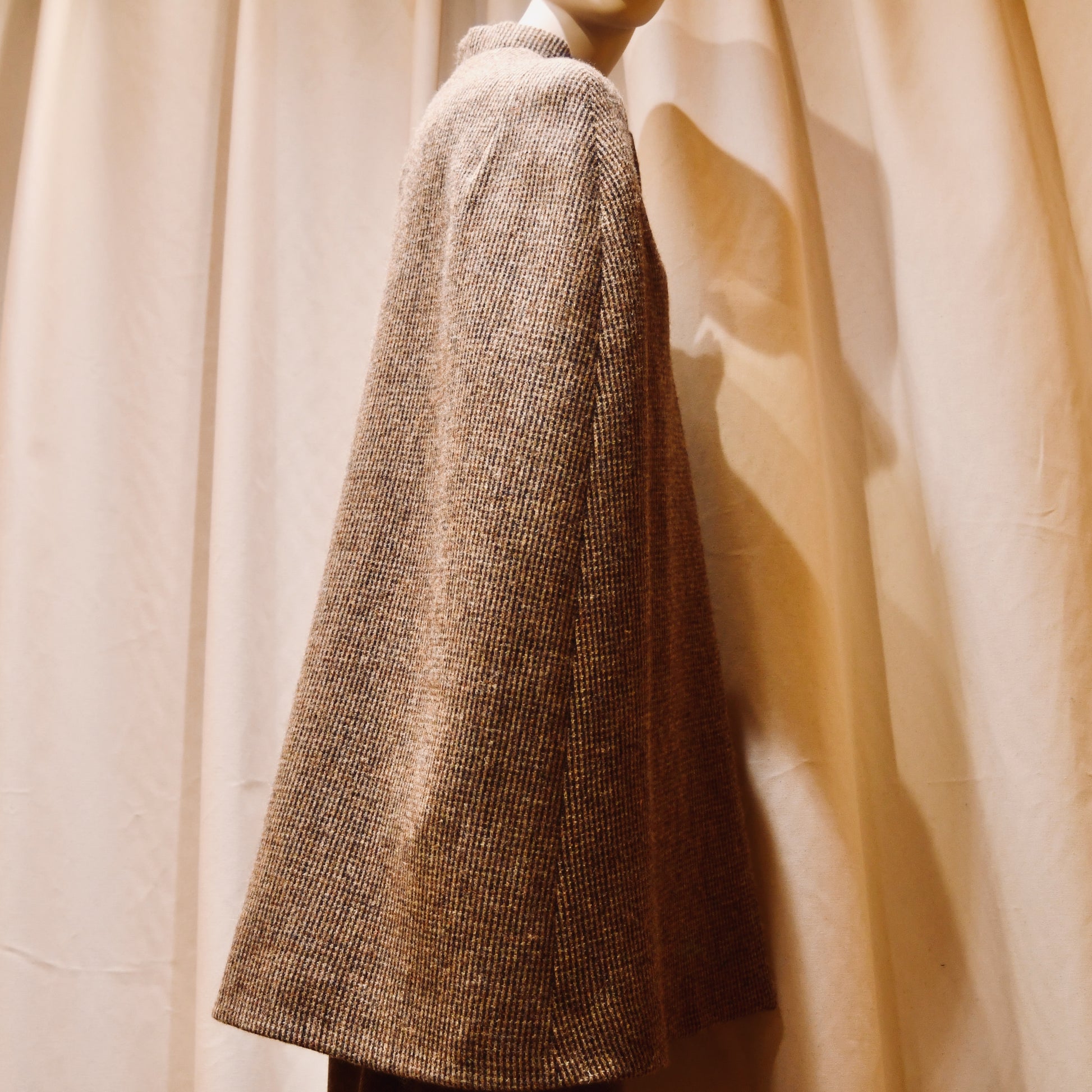 Swing Cape in Small Brown Check Lovat Tweed. Earth-toned texture and elegant style. Handmade in Britain. Back View.