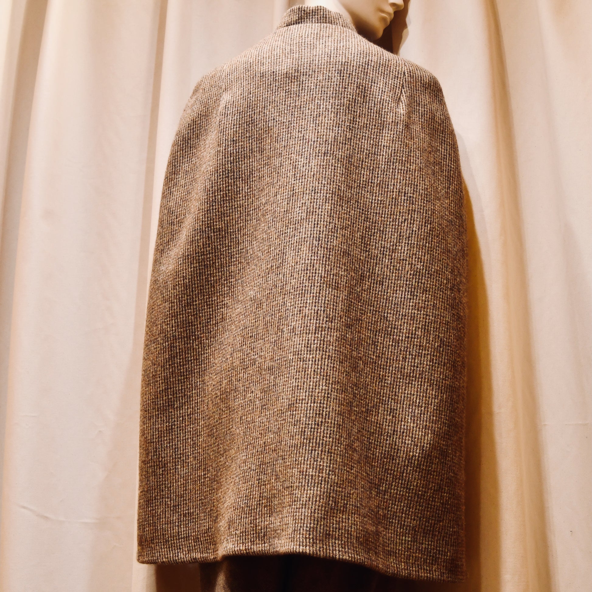Swing Cape in Small Brown Check Lovat Tweed. Earth-toned texture and elegant style. Handmade in Britain. Back View.