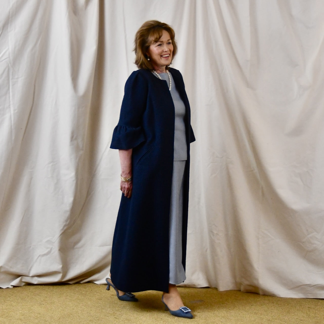 Bespoke Boucle A Line Bell Sleeve Coat. This is a Spring-summer weight coat in a navy cotton boucle from Linton Tweeds. Handmade in Britain. Side View.