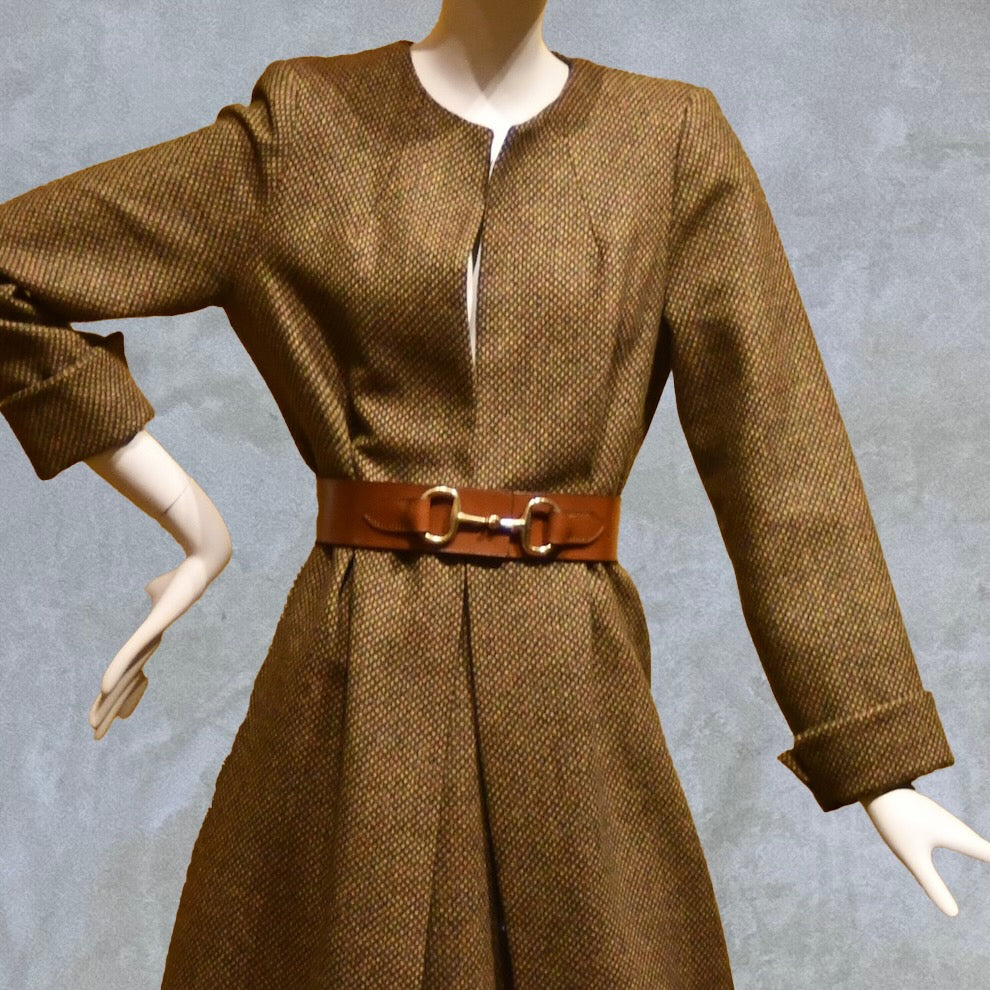 Longer length Skirted Hourglass Coat in Orange-Green Tweed. This shaped coat uses clever tailoring details to create a wonderfully flattering and easy to way skirted shape. With waist-enhancing tucks it will flatter the most testing of frames. 