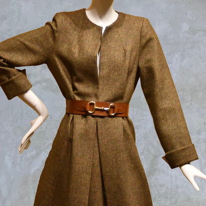 Longer length Skirted Hourglass Coat in Orange-Green Tweed. This shaped coat uses clever tailoring details to create a wonderfully flattering and easy to way skirted shape. With waist-enhancing tucks it will flatter the most testing of frames. 
