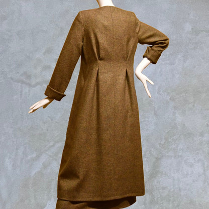 Longer length Skirted Hourglass Coat in Orange-Green Tweed. This shaped coat uses clever tailoring details to create a wonderfully flattering and easy to way skirted shape. With waist-enhancing tucks it will flatter the most testing of frames.  Entirely made in Great Britain. Back View, showing rear ruck detail.