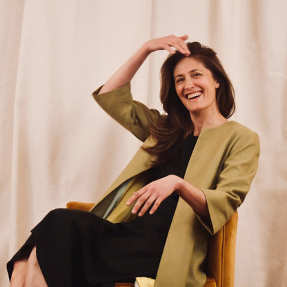 Bespoke Trapeze Coat in Silk Matka. This is a Summer Weight Silk Car Coat style shorter length coat which is available to order in a host of colours. Handmade in Great Britain. Hands in Pocket view. Seated View