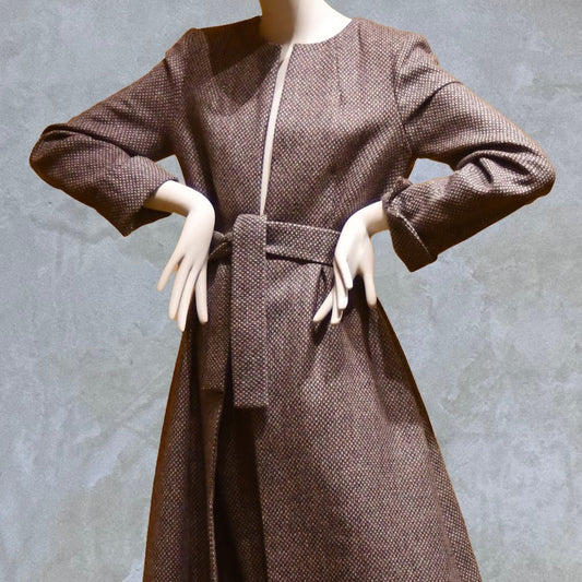 Fitted and tailored hourglass coat in Pink Patterned Tweed over a matching long skirt. Handmade in Britain. Close up on self-fabric belt.