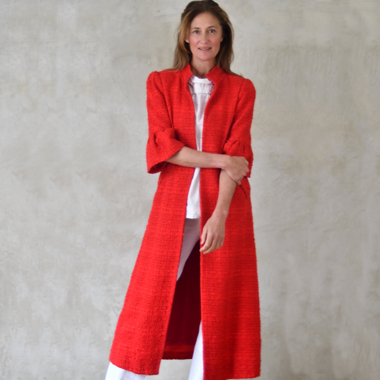 Red Linton Tweeds Boucle Bell Sleeve A-Line Coat. A longer length summer coat in a rich hued self-patterned fabric. Handmade in Britain.