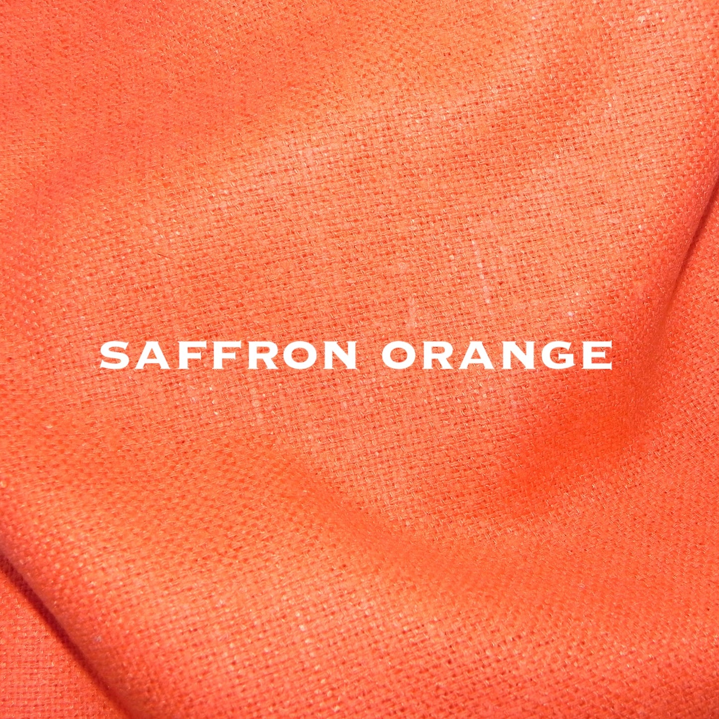 A close-up of textured fabric in a vibrant saffron orange color with the words SAFFRON ORANGE in bold white letters, showcasing British-made bespoke quality.