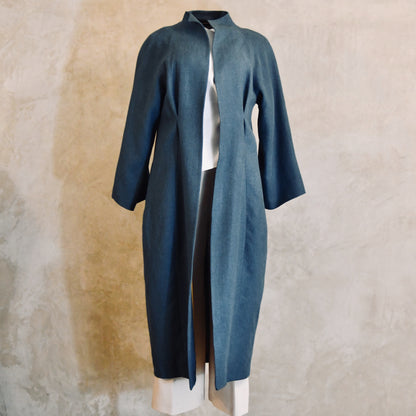 A Long Cocoon Coat in Sea-Blue Irish Linen. Wide SaLonger Length Cocoon Coat in Blue Irish Linen. An easy to wear Spring-summer coat in a delightfully flattering cocoon shape. An investment piece to last across the years. Handmade in Britain.leeves and loose, relaxed fit. The coat falls below the knees and is shown from the back. Handmade in Britain. Front View.