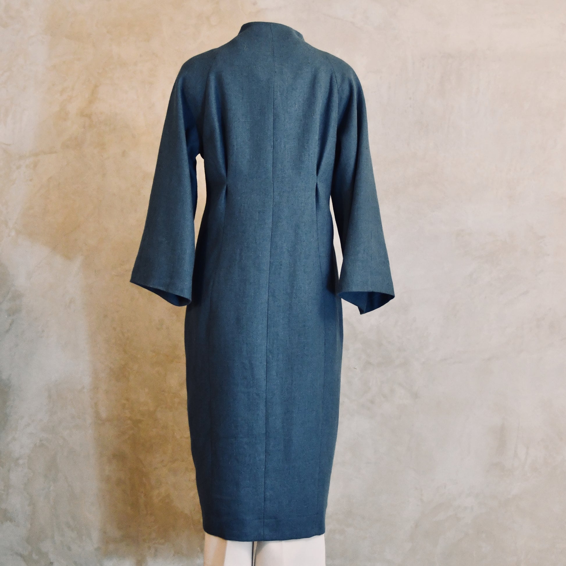 Longer Length Cocoon Coat in Blue Irish Linen. An easy to wear Spring-summer coat in a delightfully flattering cocoon shape. An investment piece to last across the years. Handmade in Britain. Back View.