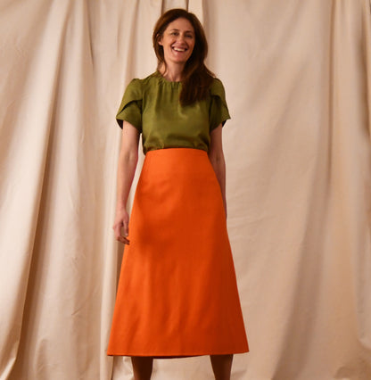 A Tulip Sleeve Blouse in lime green Silk Matka, paired with a high-waisted orange silk skirt. Handmade in Britain. 