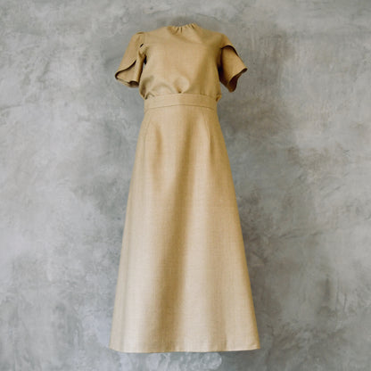 A Waisted Silk Summer A-Line Skirt in a pale coloured wheat. Featuring a fitted waist and simple, sophisticated design with an elegant drape, highlighting its simple and refined design. Handmade in Britain. Shown with a matching Tulip-Sleeved Blouse. 