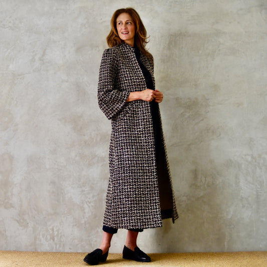 Bell Sleeve A-Line Coat in Check Linton Tweeds Boucle. Longer length ivory check boucle coat with frill cuff detail on sleeve – the perfect coat for evening wear and smart occasions. Entirely made in Great Britain. Side View.