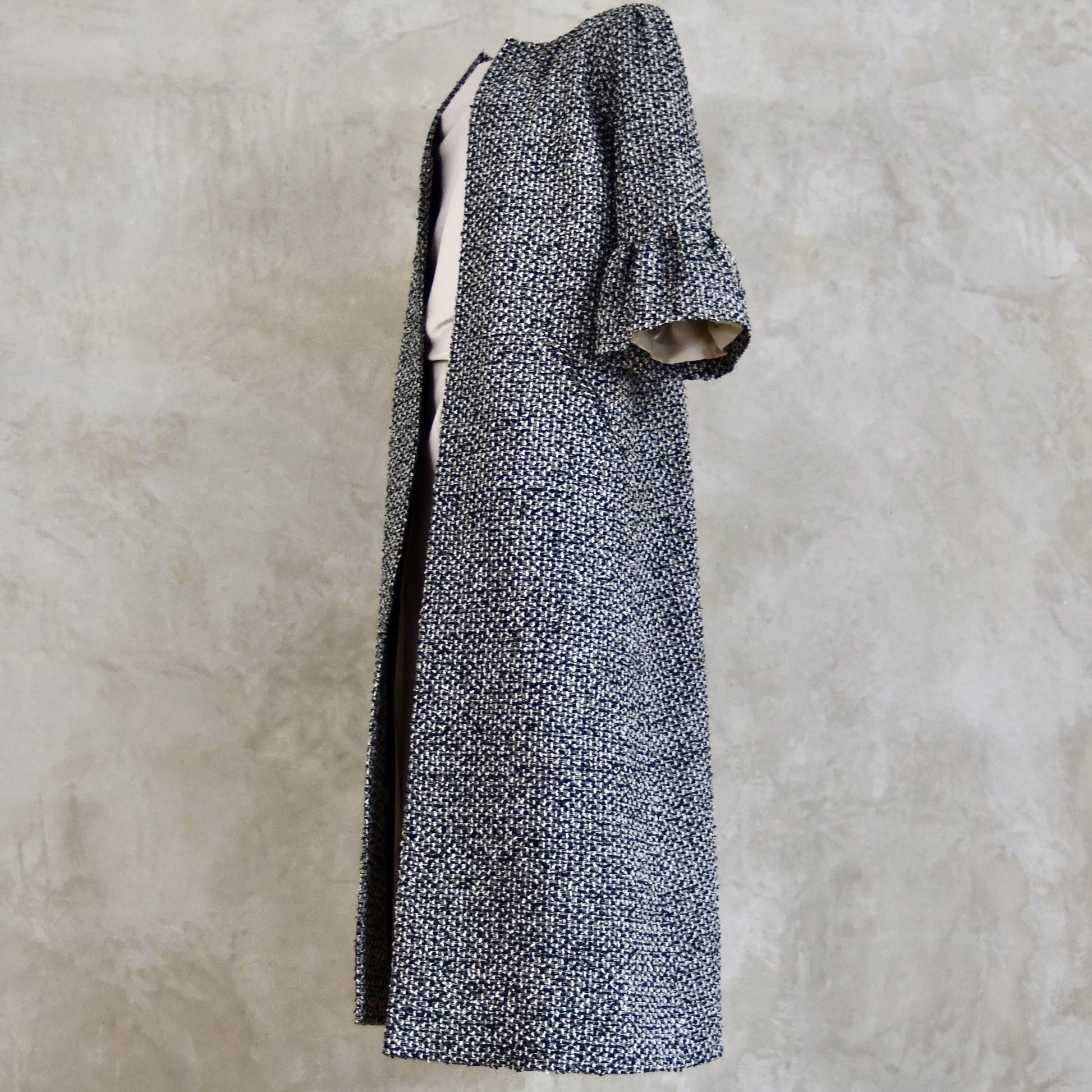 A Longer length Bell Sleeve A-Line Coat in Black and OffWhite Linton Tweeds Boucle
This is an elegant longer length A-Line coat in a patterned boucle from Carlisle. With a magnificent drape and delicate sleeve and shoulder detailing, this coat will take you everywhere. Handmade in Britain.