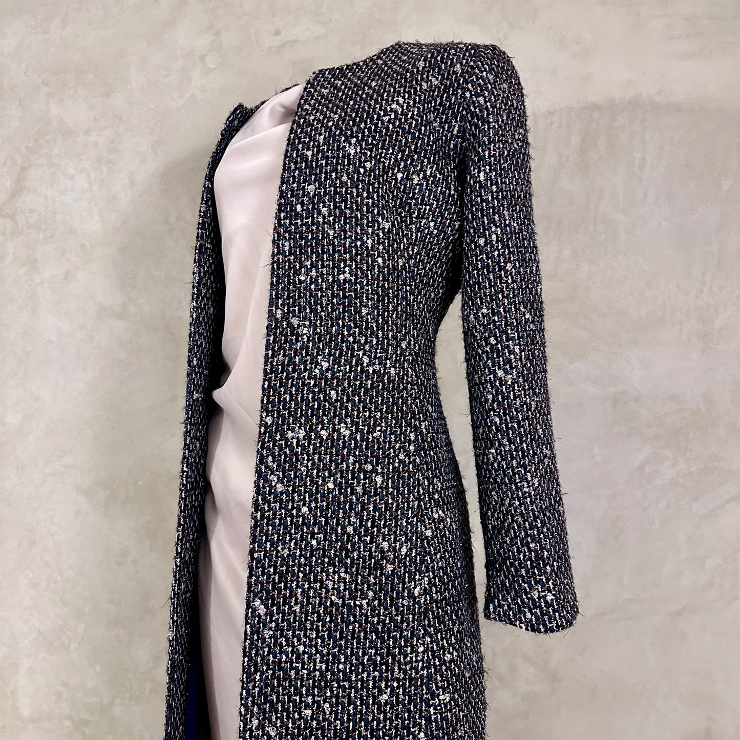 Tailored Hourglass Coat in Metallic Linton Tweeds Boucle. A Longer Length Fitted Bouclé Coat perfect for Evening Wear. An investment piece in the opera coat tradition.
Handmade in Britain.